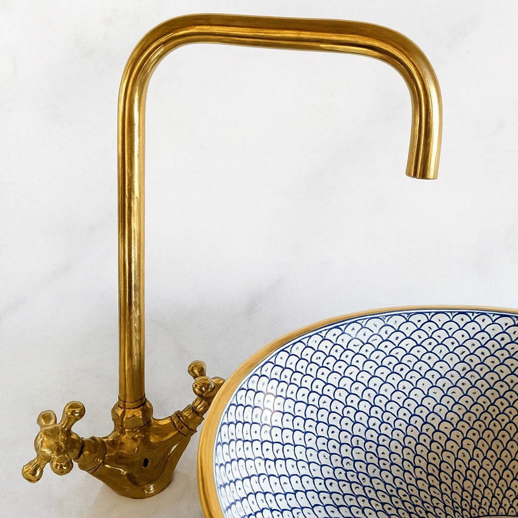 brass faucet with a blue and white patterned sink on a white background