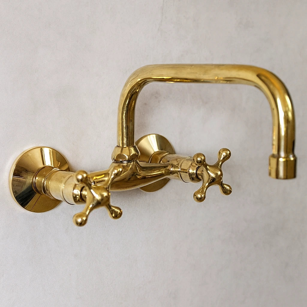 Gold wall-mounted faucet on a light gray background