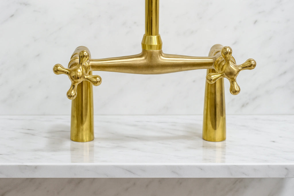Brass kitchen faucet on a marble countertop