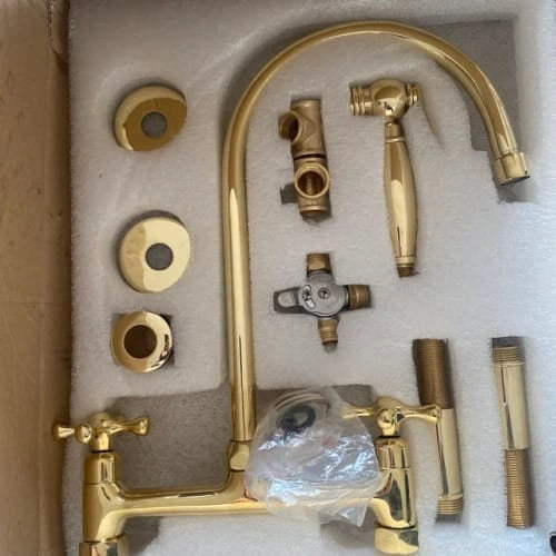 Gold faucet set with various components on a white background