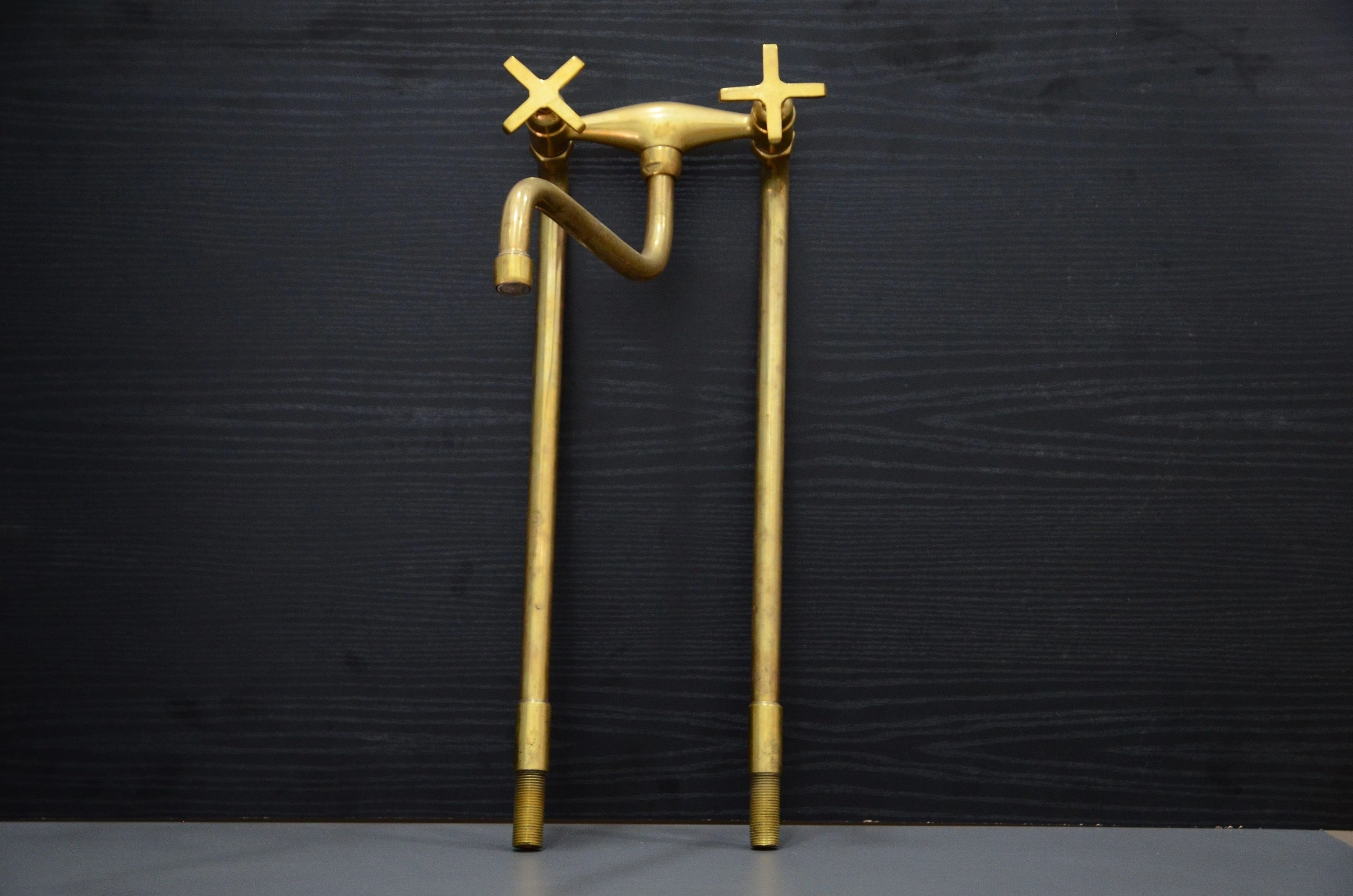 Gold faucet sculpture on a black background