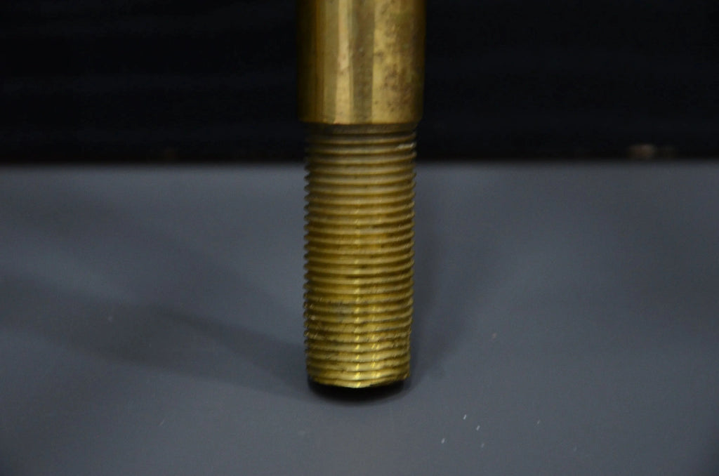 Close-up of a threaded brass rod on a dark background