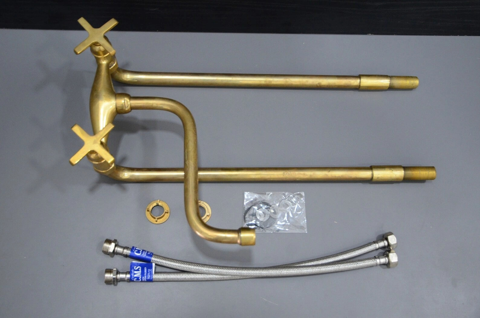 Brass plumbing components on a gray background